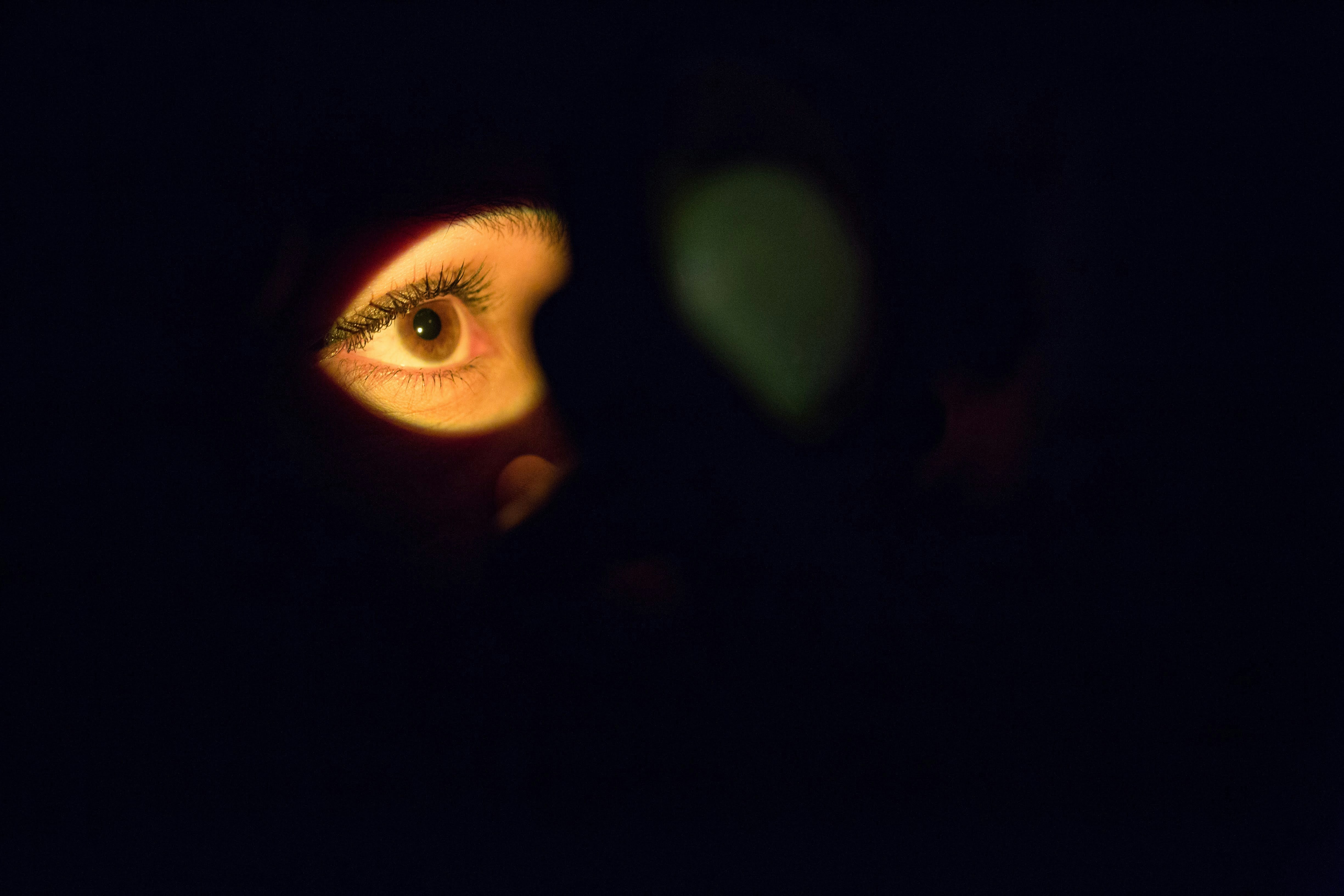 A dark room lit faintly by screen light